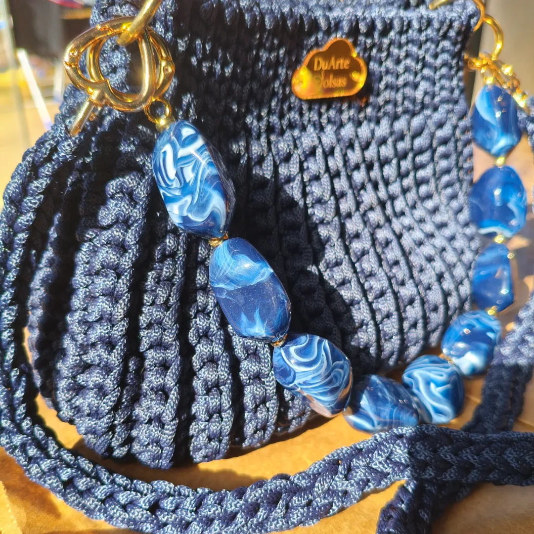 A Bolsa Pri foi criada para quem ama unir estilo, sofisticação e exclusividade em uma única peça.  Confeccionada artesanalmente em fio náutico Círculo, utilizando a combinação de pontos baixos e pontos baixo em relevo, que proporcionam uma textura elegante, firmeza e um acabamento impecável, possui um tamanho ideal para acompanhar você em passeios, eventos, encontros e ocasiões especiais, carregando seus itens essenciais com muito charme e elegância.  Um dos grandes destaques da Bolsa Pri é sua versatilidade. Ela acompanha duas opções de alças: ✨ Alça de pedraria, para um visual sofisticado e cheio de personalidade. ✨ Alça em corrente revestida com crochê, que proporciona conforto e um toque moderno.  Cada bolsa é produzida a partir de seu pedido, tornando cada peça única e especial, atendendo ao seu estilo, com o cuidado e a qualidade que somente o trabalho feito à mão pode oferecer.A Afinal, peças artesanais não seguem tendências: elas criam histórias. — foto 4